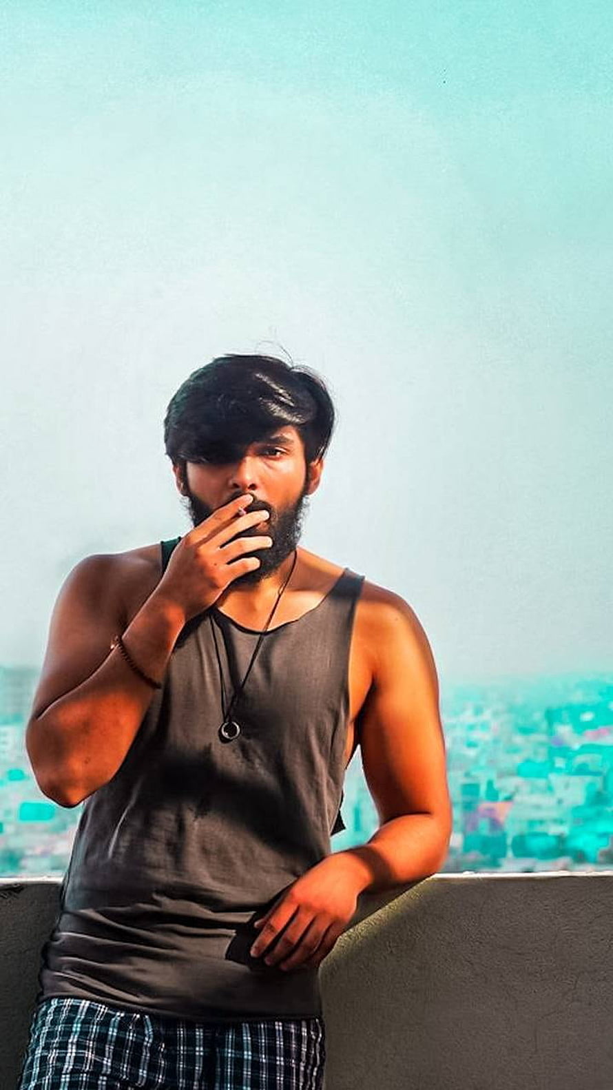 Dhruv Vikram and Adithya Varma in a moody rooftop portrait with a hazy city skyline HD phone wallpaper