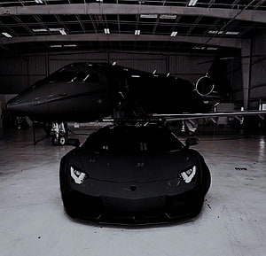 Black Lamborghini Aventador and Private Jet in Hangar HD wallpaper