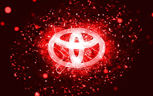 Glowing Toyota Emblem Surrounded by Vibrant Red Particle Explosion and Neon Light Effects HD wallpaper