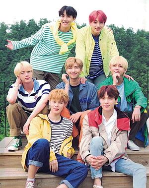 BTS Members Posing Together in Colorful Casual Outfits on Wooden Steps HD phone wallpaper