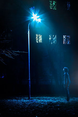 Solitary Figure Standing Under a Glowing Blue Street Lamp at Night HD phone wallpaper