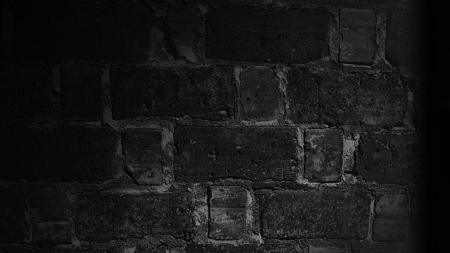 Dark Textured Brick Wall Background with Deep Shadows and Rough Stone Surface HD wallpaper