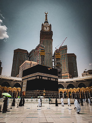 The Kaaba in Makkah with the Makkah Clock Tower rising behind the Grand Mosque courtyard HD phone wallpaper