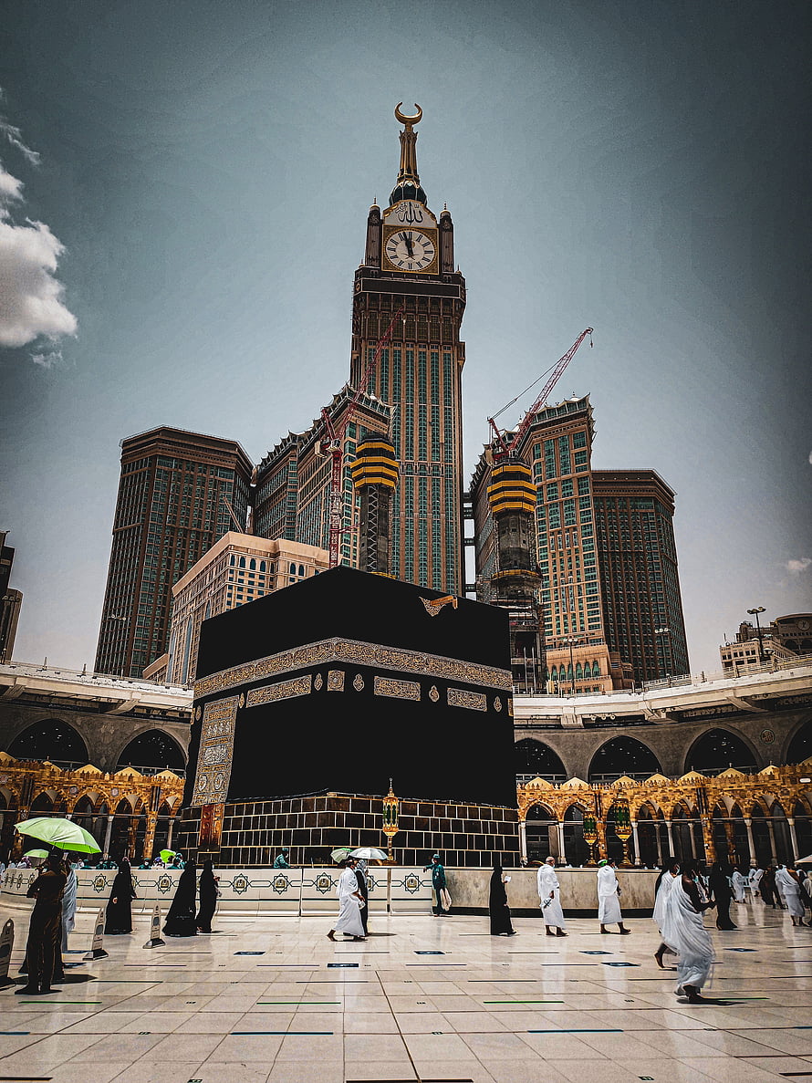 The Kaaba in Makkah with the Makkah Clock Tower rising behind the Grand Mosque courtyard HD phone wallpaper