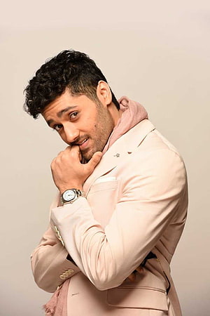 Utkarsh Sharma in a beige blazer and pink hoodie posing for a studio portrait HD phone wallpaper