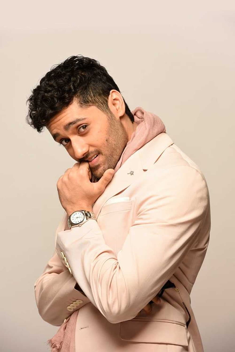 Utkarsh Sharma in a beige blazer and pink hoodie posing for a studio portrait HD phone wallpaper