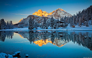 Alpine Mountain Lake Reflection at Sunrise with Snow-Covered Pines and Chalet HD wallpaper