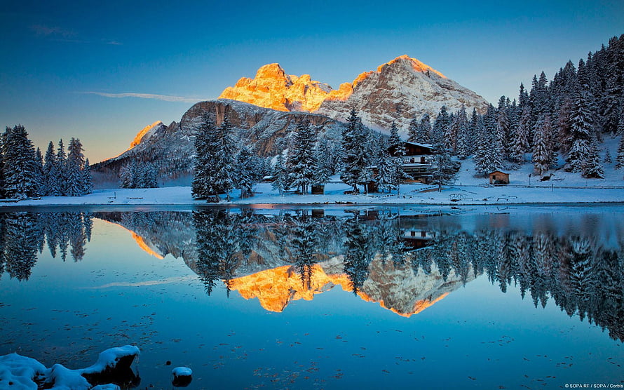 Alpine Mountain Lake Reflection at Sunrise with Snow-Covered Pines and Chalet HD wallpaper