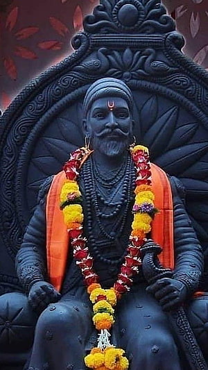Shivaji Maharaj Black Statue with Marigold Garland and Orange Sash HD phone wallpaper