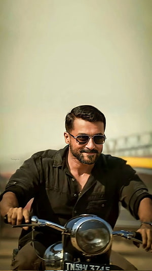 Surya Riding a Classic Motorcycle in a Black Shirt and Sunglasses HD phone wallpaper