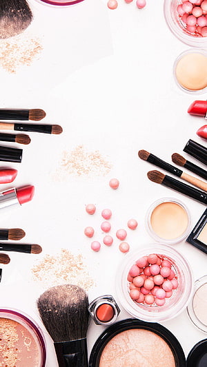 Flat lay of makeup brushes, lipsticks, and powder on a white background HD phone wallpaper