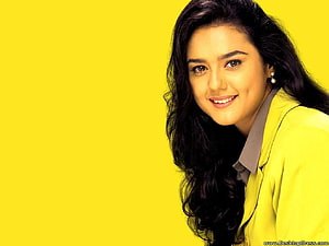Preity Zinta smiling portrait in yellow jacket against a bright yellow background HD wallpaper