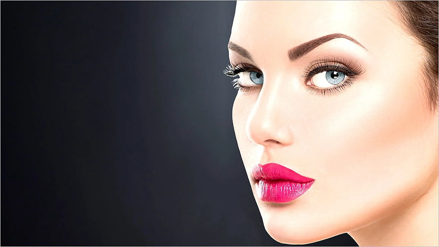 Close-up beauty portrait of a woman with bold pink lips and blue eyes against a dark background HD wallpaper