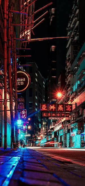 Neon-lit Hong Kong street at night with glowing signs and bamboo scaffolding HD phone wallpaper