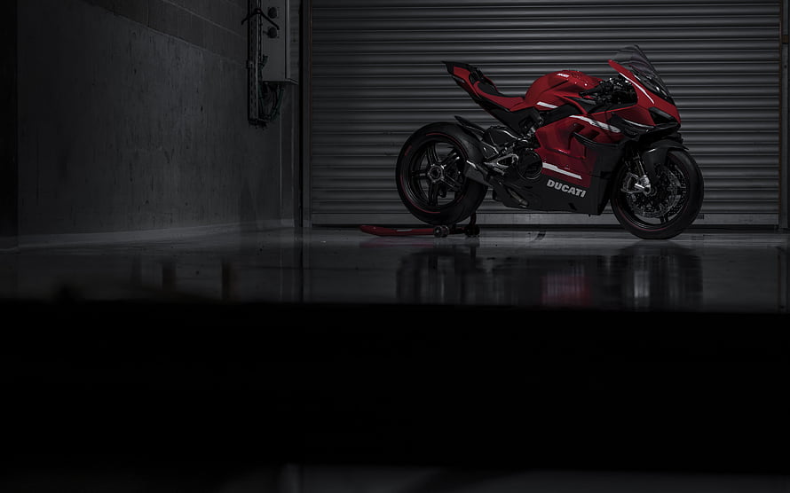 Ducati Superleggera V4 Red Sportbike Parked in Dark Industrial Garage Setting HD wallpaper