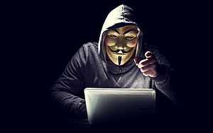 Anonymous Guy Fawkes Mask Hacker Pointing at Laptop in Dark Room HD wallpaper