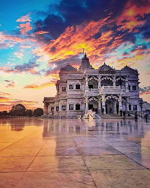Vrindavan Temple Architecture at Sunset with Vibrant Sky and Reflective Marble Courtyard HD phone wallpaper