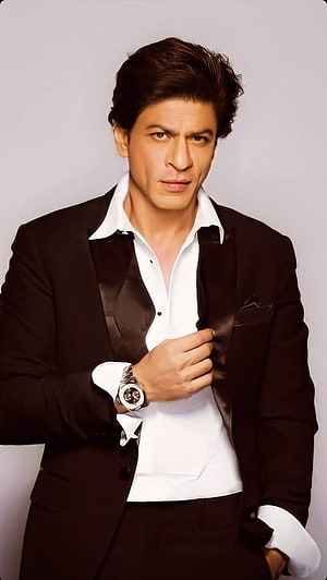 Shah Rukh Khan in a black tuxedo jacket and white shirt with a wristwatch HD phone wallpaper