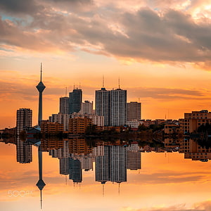 Milad Tower and Tehran Skyline Reflected in Water at Golden Hour HD phone wallpaper