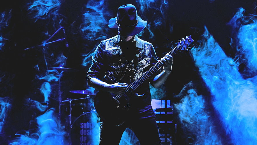 Gustavo Cerati performing live with electric guitar under blue stage smoke HD wallpaper