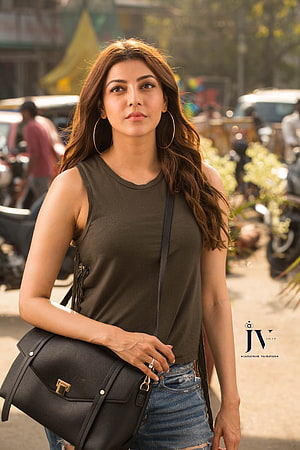 Kajal Agarwal in olive tank top and distressed denim with black crossbody bag HD phone wallpaper