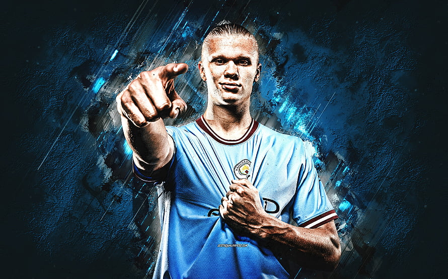 Erling Haaland in Manchester City kit pointing forward against a dark blue textured backdrop HD wallpaper
