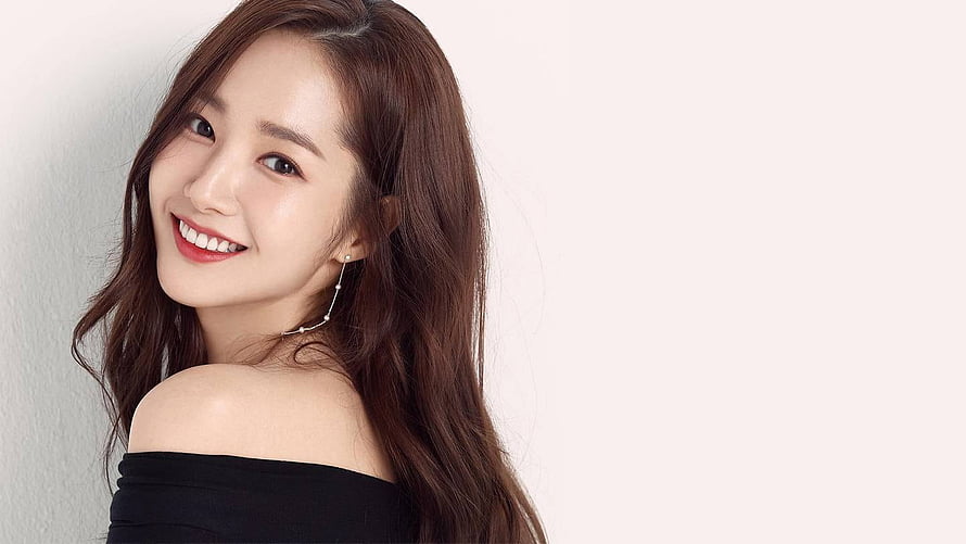 Park Min Young smiling portrait in black off-shoulder top with long wavy hair HD wallpaper