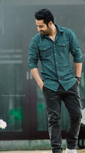 Jr NTR in a teal button-down shirt and black trousers with a relaxed confident pose HD phone wallpaper