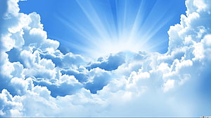 Bright Sunburst Breaking Through Fluffy White Clouds in a Clear Blue Sky HD wallpaper