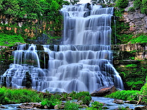 Misty Tiered Waterfall Cascading Through Lush Green Forest Rocks HD wallpaper