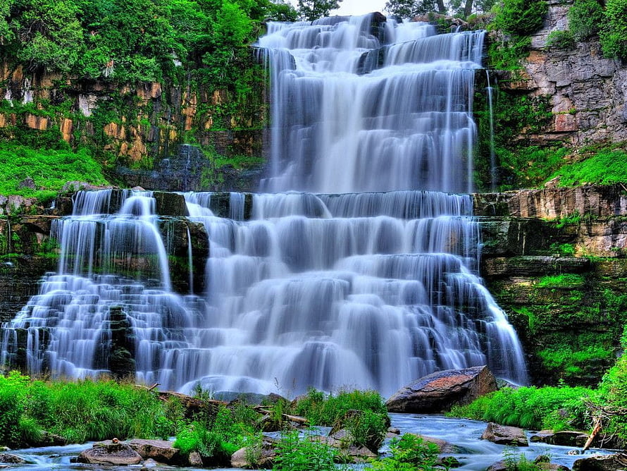 Misty Tiered Waterfall Cascading Through Lush Green Forest Rocks HD wallpaper