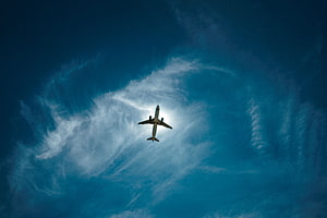 Commercial Airplane Cruising Through Deep Blue Sky With Wispy Cirrus Clouds HD wallpaper