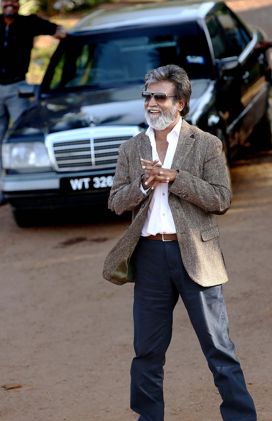 Rajinikanth in a brown blazer and sunglasses standing in front of a black Mercedes-Benz SUV HD phone wallpaper