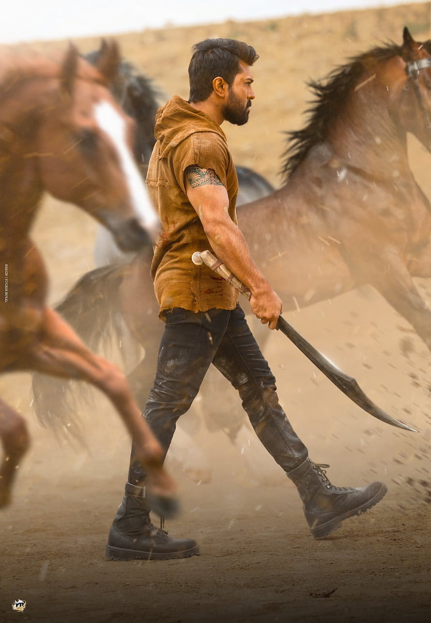Ram Charan in RRR wielding a sword in a dusty arena with galloping horses HD phone wallpaper
