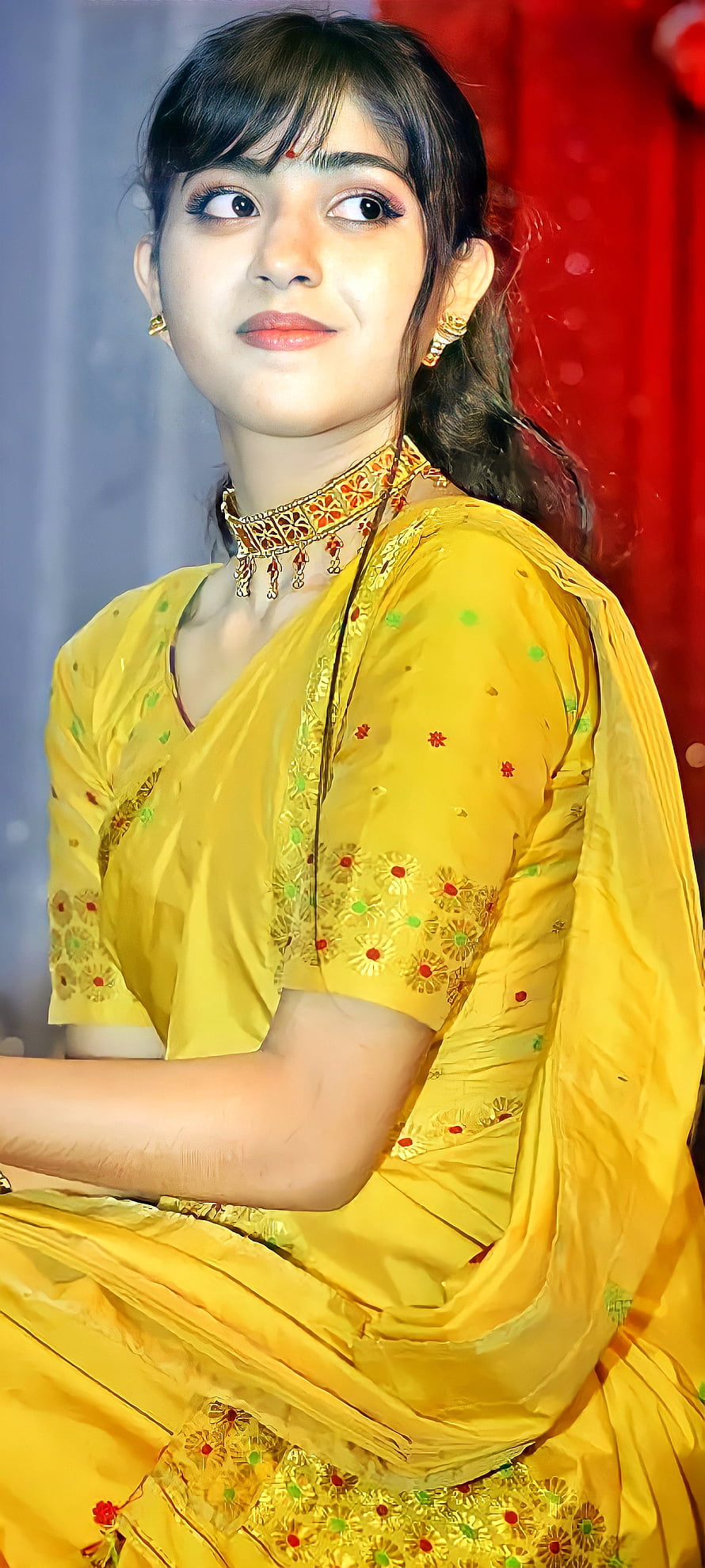 Young woman in a yellow embroidered lehenga with traditional gold jewelry and red backdrop HD phone wallpaper
