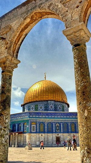 Dome of the Rock framed by ancient stone archway in Jerusalem HD phone wallpaper