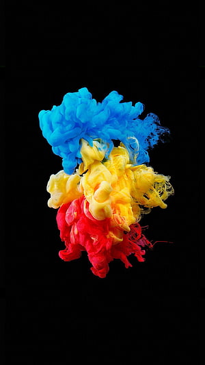 Vibrant Blue Yellow and Red Ink Clouds Diffusing in Water Against Black Background HD phone wallpaper