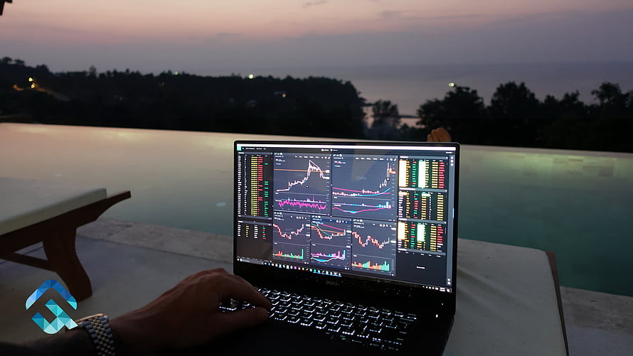 Laptop displaying stock market charts and trading data on a poolside deck at dusk HD wallpaper