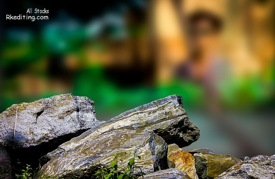 Weathered Rock Formation with Lush Green Foliage in Soft Focus Background HD wallpaper