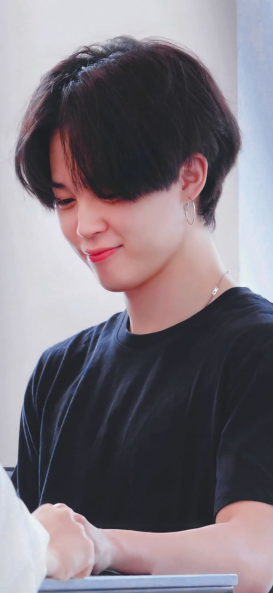 Jimin from BTS in a black t-shirt with hoop earrings and a gentle smile HD phone wallpaper