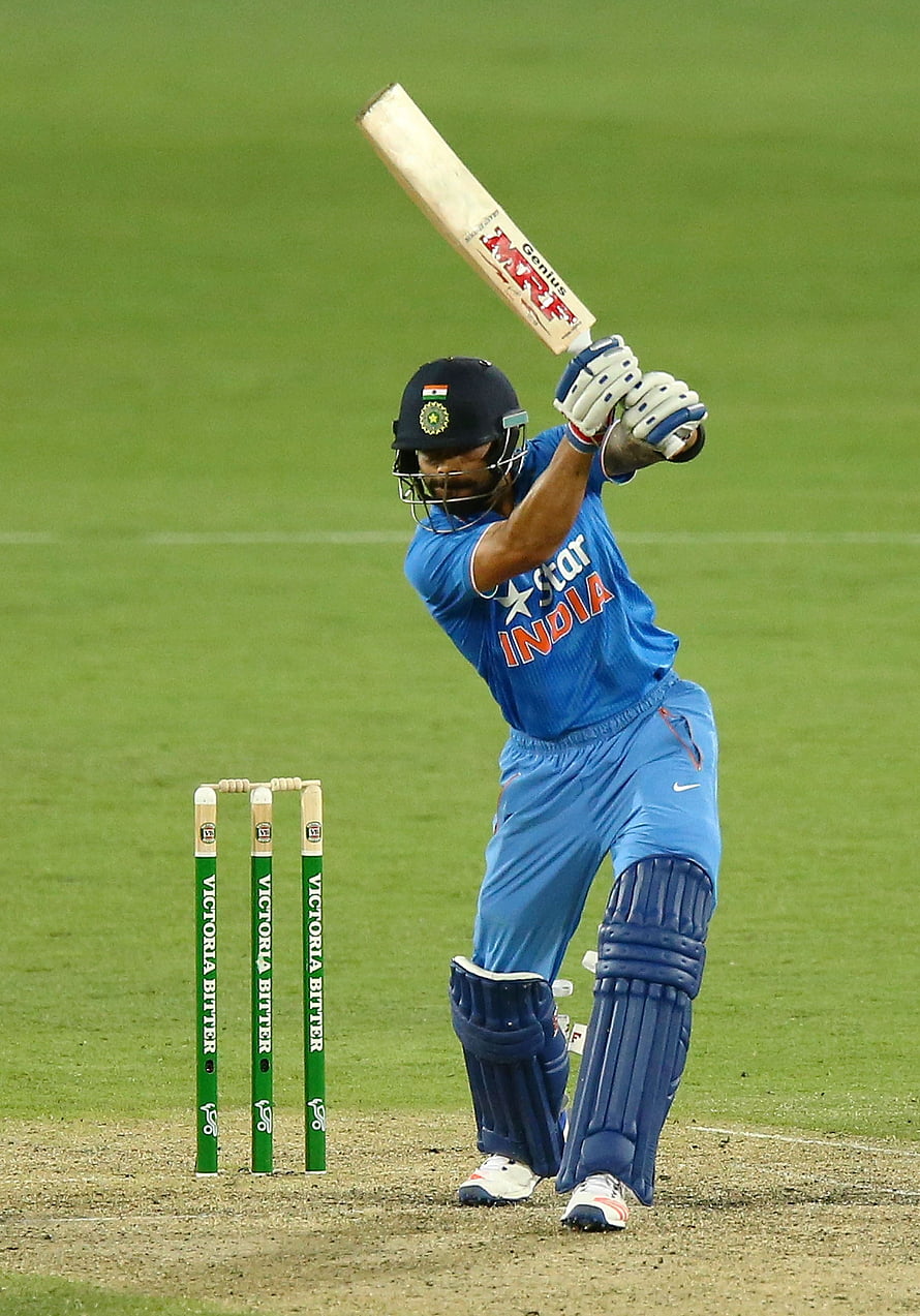Virat Kohli executing a powerful cover drive in his blue India cricket jersey HD phone wallpaper