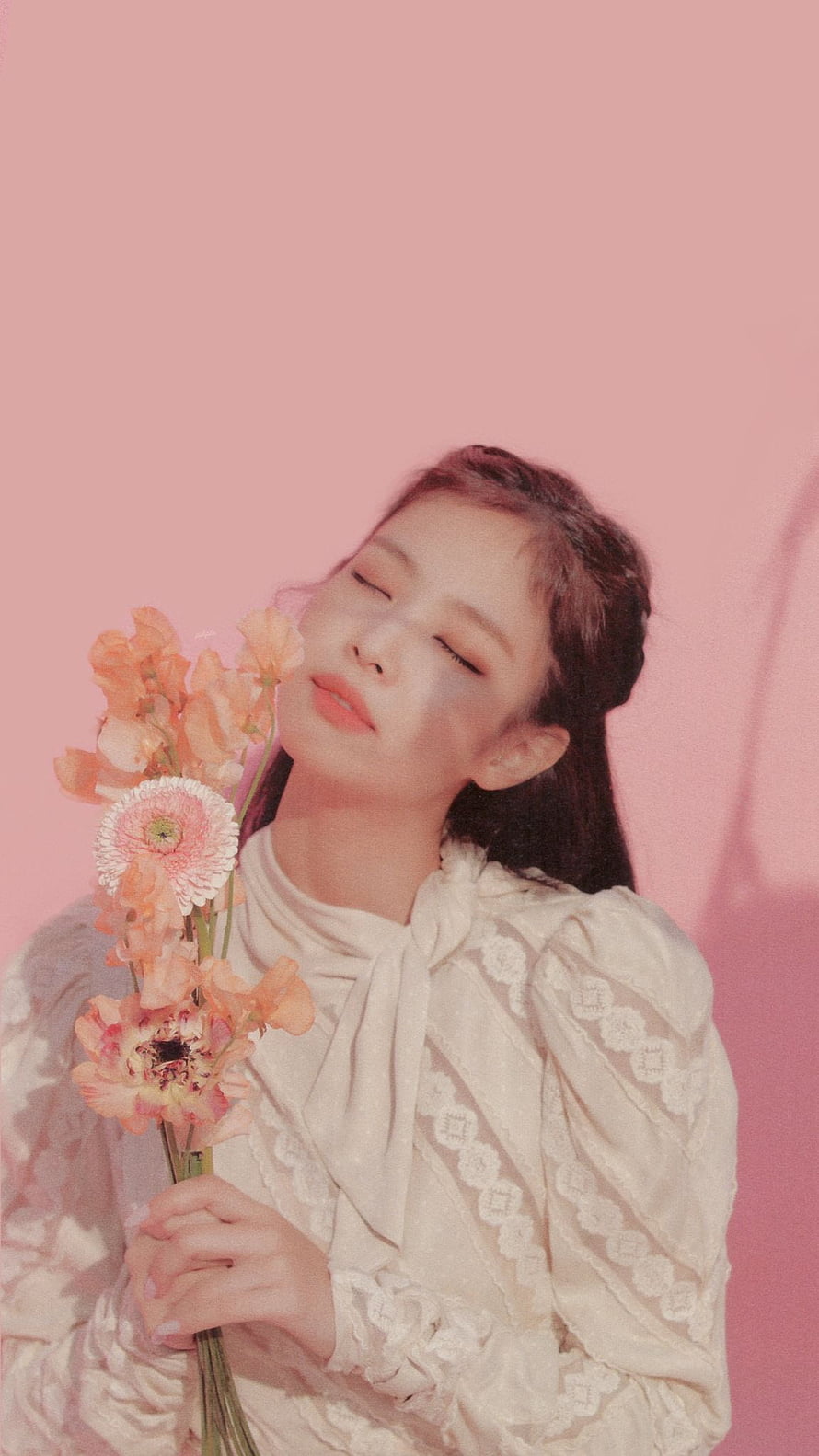 Jennie from Blackpink holding a bouquet of peach flowers against a soft pink studio backdrop HD phone wallpaper