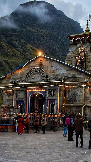 Kedarnath Temple at Dusk with Misty Himalayan Peaks and Devotees in the Foreground HD phone wallpaper
