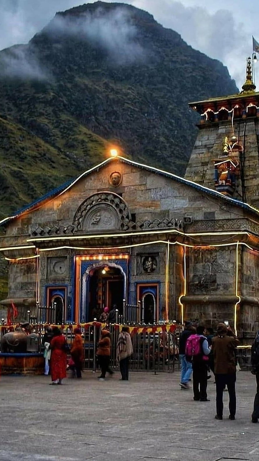Kedarnath Temple at Dusk with Misty Himalayan Peaks and Devotees in the Foreground HD phone wallpaper