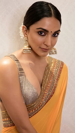 Kiara Advani in a Golden Saree with Traditional Jewelry and Floral Hair Accessory HD phone wallpaper