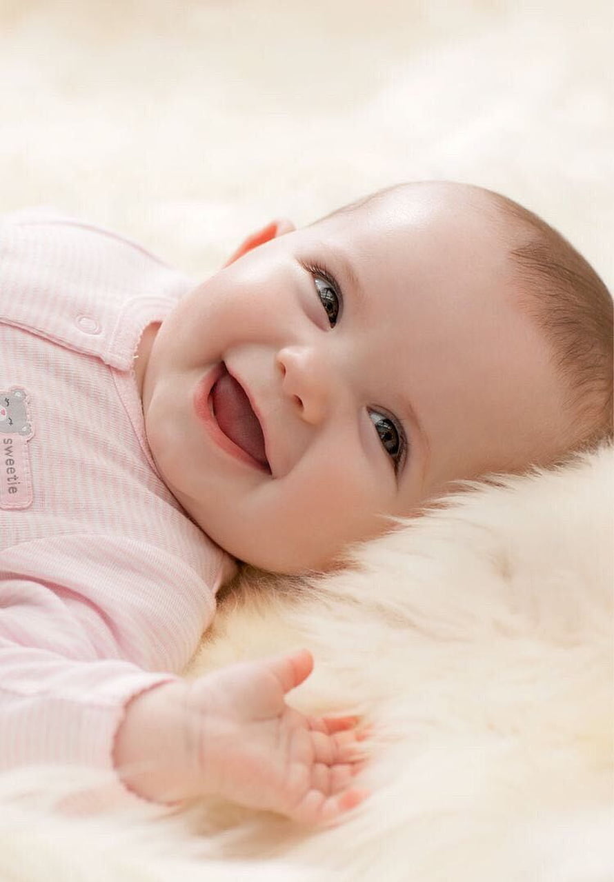 Smiling Baby Girl Lying on Soft White Fur Wearing Pink Striped Onesie HD phone wallpaper