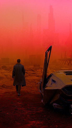 Blade Runner 2049 dystopian cityscape with lone figure and wrecked car in red haze HD phone wallpaper