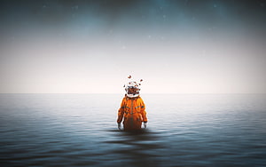 Lone Astronaut in Orange Suit Standing in Calm Ocean with Butterflies HD wallpaper