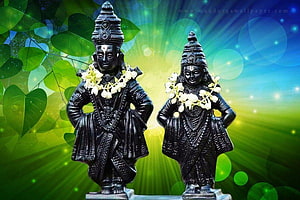 Black Stone Idols of Vitthal and Rukmini Adorned with White Flower Garlands HD wallpaper