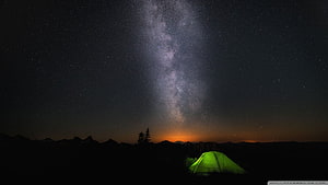 Glowing Green Tent Under the Milky Way Galaxy in a Dark Mountain Landscape HD wallpaper